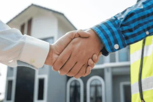 Handshake between landlord and tenant in front of commercial property representing commercial lease agreements in Thailand.